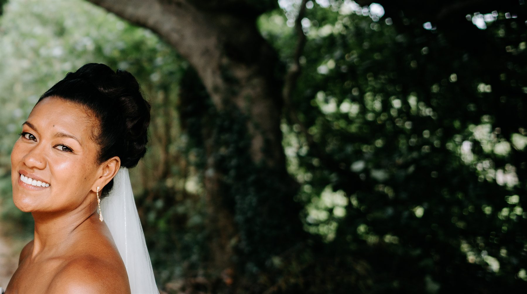 Bride with an updo and veil among the trees