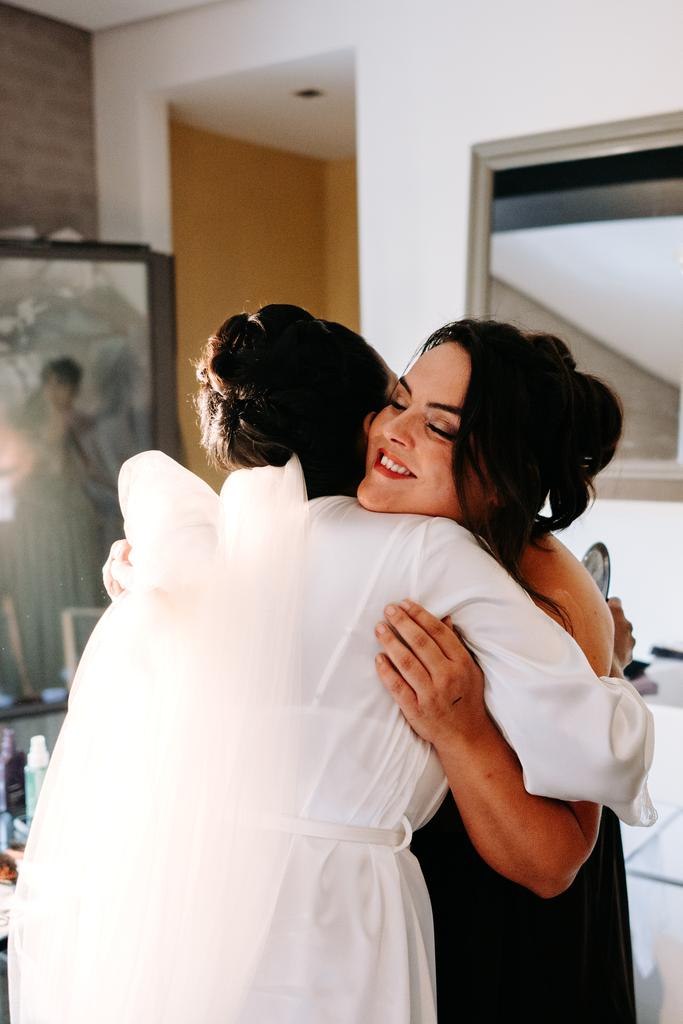 Nadia hugs the bride while getting ready